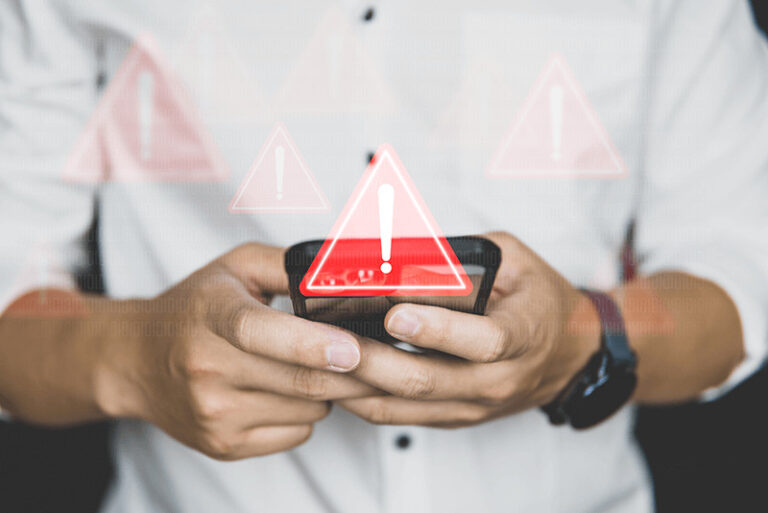 person texting on their phone which is surrounded by red warning signs